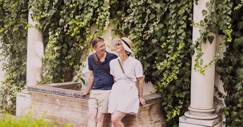 Spain Couple Relaxing In Front Of Vegetation And Columns Hero