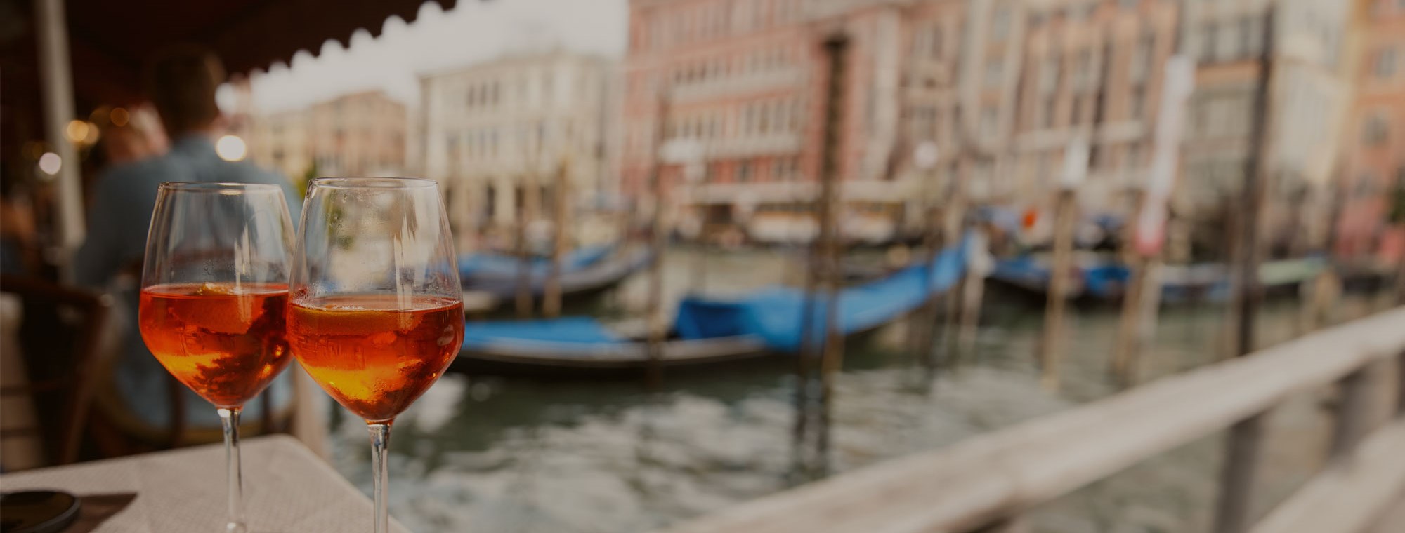Venice, Italy, enjoying an aperol spritz & watching the gondolas float the canal on our Multi-Country Europe Tours