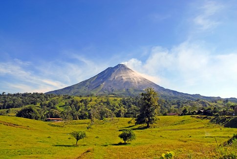 Bright blue sky and green grass around Arenal Volcano, Costa Rica