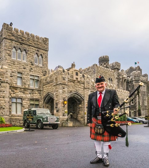 Ashford Castle with piper in front, Ireland