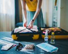 Expert Woman Packing Suitcase Sanitizer Toiletries Yellow Luggage Masks