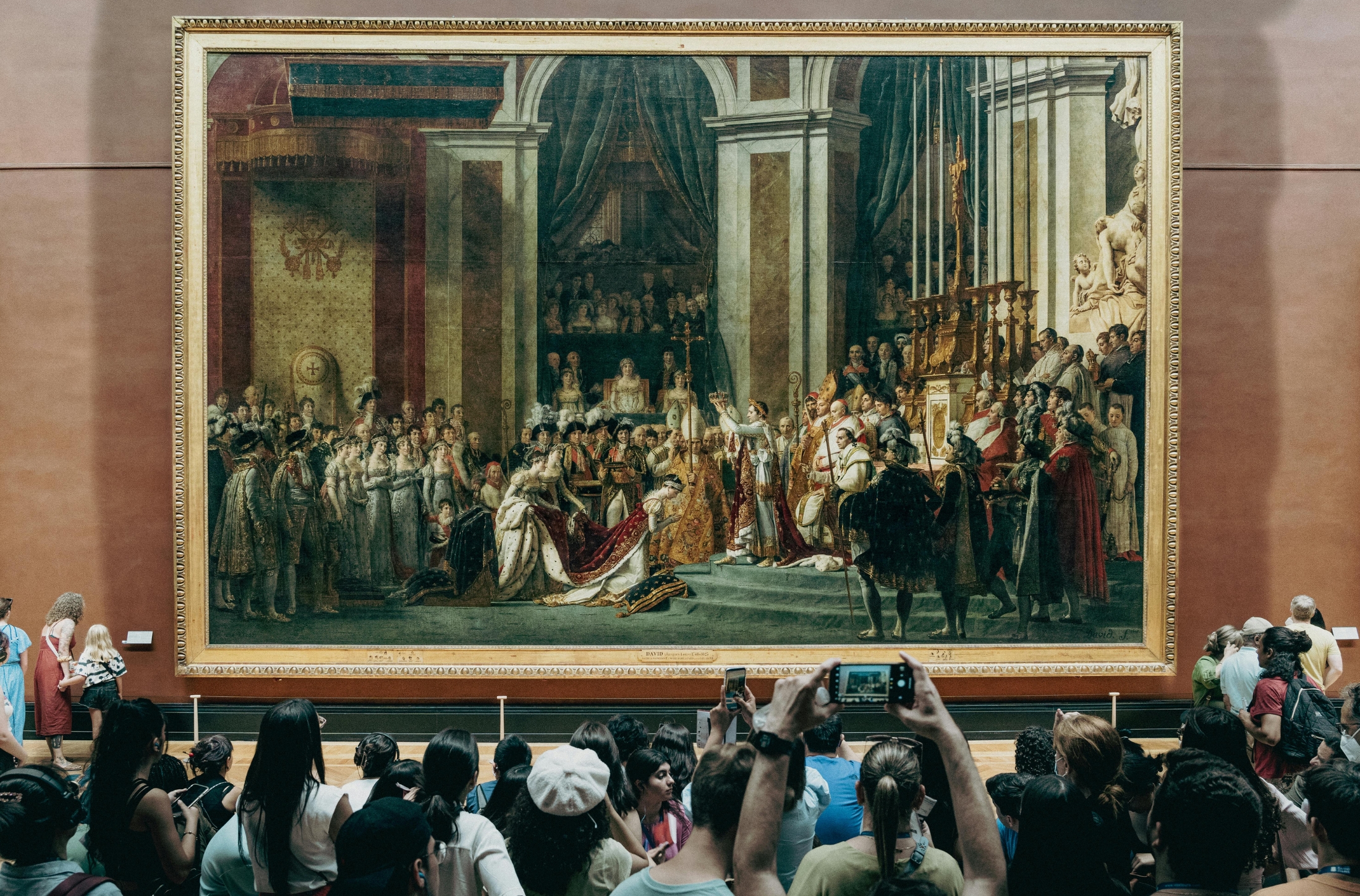 In Paris, France, at the Louvre Museum one of the top exhibits to see is the The Coronation Of Napoleon painting by Jacques-Louis David