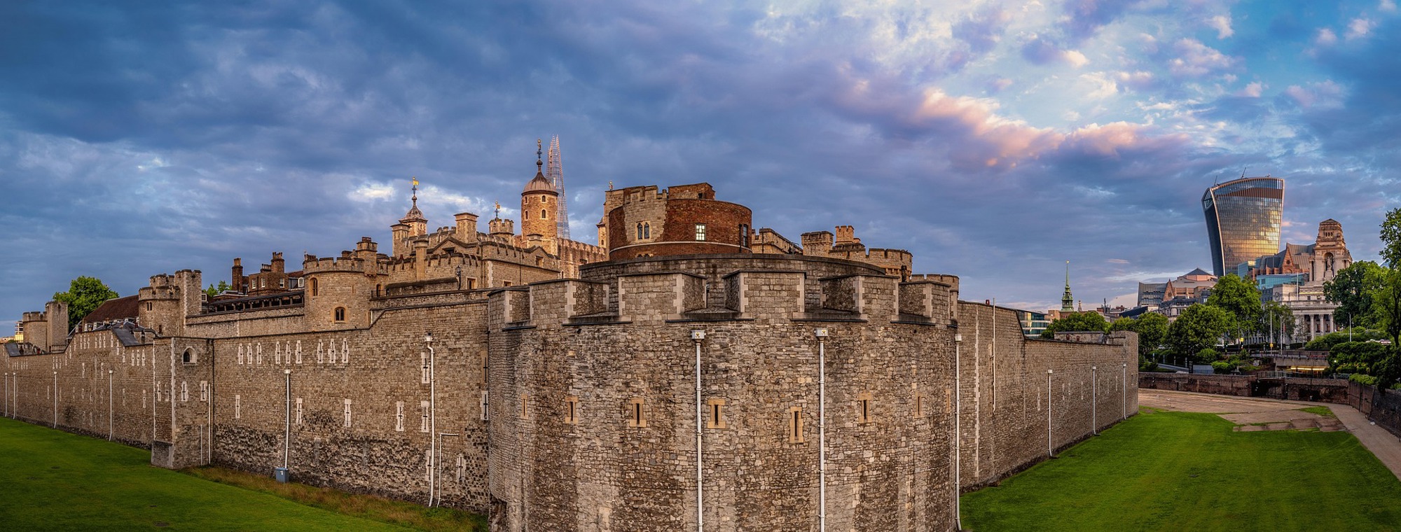 Book a guided tour with Grand European Travel and visit the Tower of London, a historic castle on the north bank of the River Thames in central London, featuring the White Tower built by William the Conqueror, surrounded by outer walls and fortifications, with the modern London skyline as a contrasting backdrop.