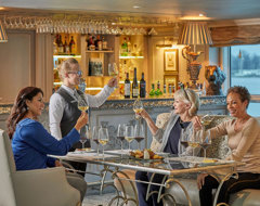 Uniworld Women Toasting Wine In Lounge On Ship With Server